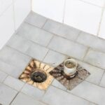 Shower floor with trap taken out showing blockage