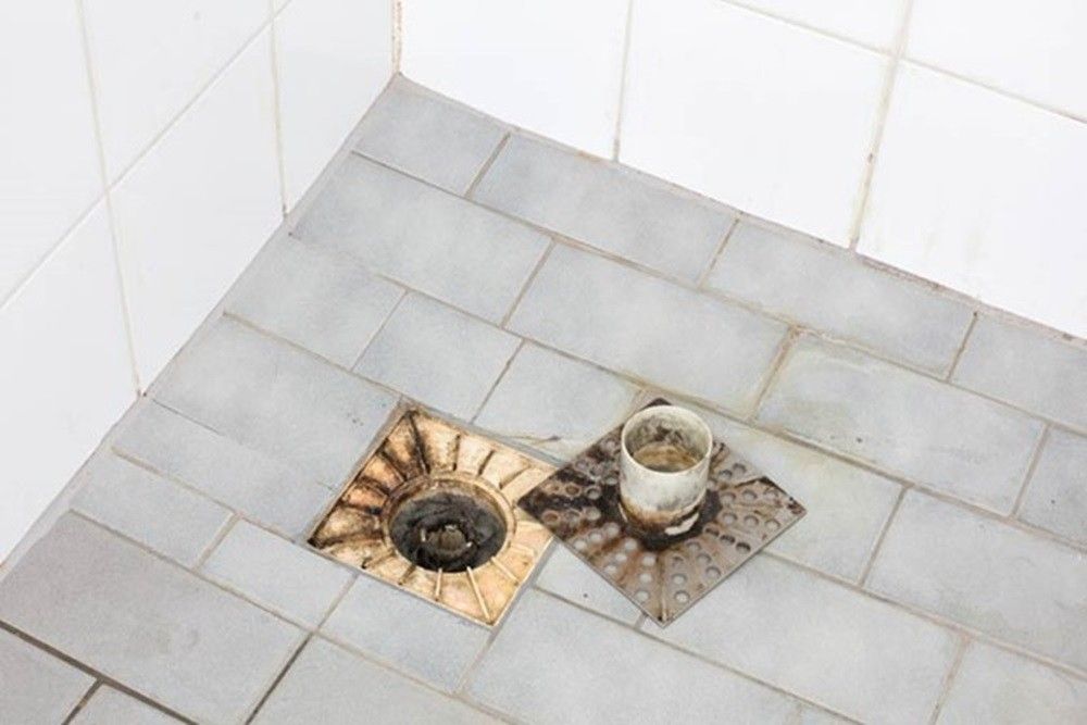 Shower floor with trap taken out showing blockage